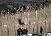 Des migrants qui escaladent la frontiere avec l'Espagne à Melila.