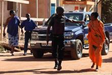 Un membre des forces spéciales maliennes évacue deux femmes.
