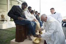 Le pape en train de laver les pieds d'un migrant.
