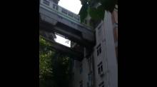 Un métro traverse un immeuble à Chongqing en Chine