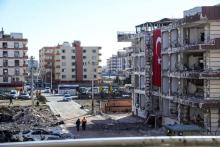 Des turcs passent, le 18 février 2017, sur le site où un véhicule piégé a explosé, à Viransehir dans