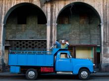 Un cubain lit le journal perché sur son camion le 31 mars 2017 à La Havane