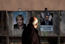 Un homme passe devant les affiches de campagne des deux candidats à la présidentielle, Marine Le Pen