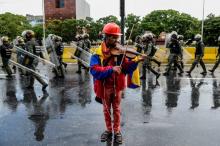 L'opposant Wuilly Arteaga joue du violon davant la police antiémeute, le 24 mai 2017 à Caracas, au V