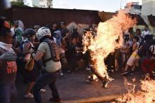 Des manifestants de l'opposition mettent le feu à un voleur présumé pendant une manifestation contre