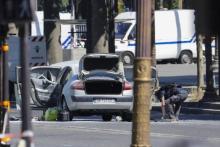 La voiture de l'assaillant des Champs-Elysées examinée par un démineur.
