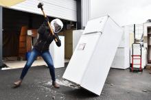 Un homme détruit un frigo à coups de masse, le 30 juin 2017 dans une entreprise de déménagement à No