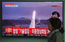 Une femme passe devant un écran de télévision montrant un nouveau tir de missile en Corée du nord, l