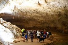 Des touristes écoutent un guide lorsd'une visite de la grotte naturelle de Choranche, dans la région