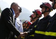 Le ministre de l'Intérieur Gérard Collomb (g) salue des pompiers, le 5 août 2017 à Palneca en Corse-