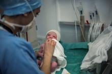 Une sage-femme nettoie un nouveau-né juste après sa naissance à la maternité l'hôpital de la Croix-R