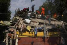 Des équipes de secours recherchent des survivants dans les décombres d'un bâtiment après un séisme, 