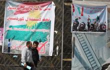 Des Irakiens passent devant une affiche pour le référendum d'indépendance du Kurdistan, le 24 septem