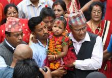 Trishna Shakya (C), 3 ans, dans les bras de son père (G), le 28 septembre 2017 à Katmandou