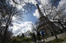 Des personnes font leur jogging au pied de la tour Eiffel à Paris le 5 avril 2015
