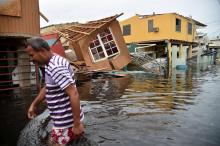 Un homme marche dans la ville de Catano à Porto Rico inondée après le passage de l'ouragan Maria, le