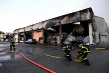 Des pompiers éteignent l'incendie d'un bâtiment de la gendarmerie à Grenoble le 21 septembre 2017