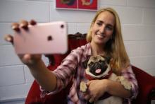 Aida Martinez prend un selfie avec Mia, star du Pugs & Pals cafe, bar dédié aux amoureux du carlin (