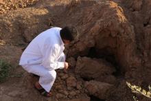 Un Irakien examine le site où sont enterrés des jihadistes de l'EI à Dhoulouïya, à 90 km au nord de 