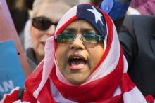 Une femme couverte d'un voile aux couleurs du drapeau américain participe à une manifestation contre