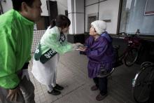 Asami Miwa (g), ancienne hôtesse de l'air et candidate du Parti de l'Espoir, parle avec une femme âg