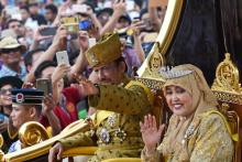 Le sultan du Brunei Hassanal Bolkiah (c) sur un chariot tiré par ses sujets, salue la foule, lors de