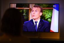 Une femme regarde l'interview télévisée du président de la République Emmanuel Macron, le 15 octobre