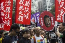 Des manifestants brandissent un portrait du président chinois Xi Jinping lors d'une manifestation "c