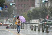 Une japonaise marche dans les rues de Tokyo bravant des pluies diluviennes, le 22 octobre 2017, à l'