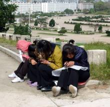 Des jeunes Nord-Coréennes regardent leurs téléphones portables, le 22 septembre 2010 dans un parc de