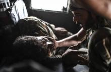 Un combattant des Forces démocratiques syriennes réconforte son compagnon d'armes blessé, le 24 sept