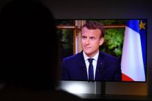 Une femme regarde Emmanuel Macron lors d'un entretien télévisé, à Rennes, le 15 octobre 2017