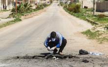 Un Syrien récupère pour analyse un oiseau mort sur les lieux d'une attaque chimique présumée, le 5 a