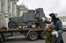 Un acteur costumé en Tsar Pierre le Grand montre le 24 octobre à un enfant le véhicule blindé bolché