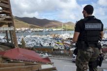 Un gendarme devant des bateaux endommagés après le passage de l'ouragan Irma sur l'île de Saint-Mart