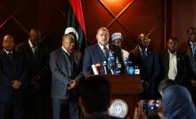 Un responsable du ministère libyen des Affaires étrangères, Salah Abou-Raguigah (C), lit un communiq