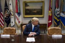 Le président américain Donald Trump entre deux chaises vides laissées par le sénateur démocrate de N