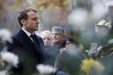 Le président Emmanuel Macron se recueille après avoir déposé une gerbe devant la statue de George Cl