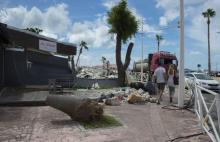 Des passants marchent près d'un bâtiment endommagé par les passages des ouragans Irma et Maria, à Sa