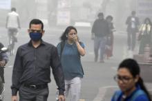 Des passants dans une rue de New Delhi lors d'un épisode de forte pollution, le 8 novembre 2017