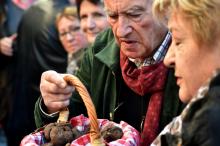 Un acheteur examine un panier de truffes au marché qui lui est consacrée à Lalbenque, le 6 décembre 