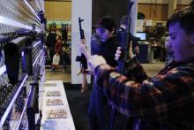Un jeune garçon examine un fusil lors d'un salon du lobby des armes à feu (NRA), le 10 février 2017 