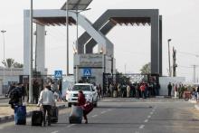 Des Palestiniens munis de leurs bagages arrivent au point de passage avec l'Egypte, ouvert pour troi