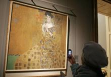 Une femme prend en photo d'un portrait d'Adèle Blocher-Bauer peint par Gustave Klimt le 17 janvier 2
