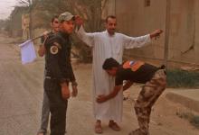 Des habitants d'Al-Qaïm, dans l'ouest de l'Irak, sont fouillés par des membres des forces irakiennes