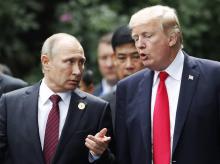 Les présidents russes Vladimir Poutine (g) et américain Donald Trump (d)conversent lors du Sommet de