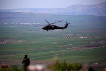 Un hélicoptère, de la coalition dirigée par les États-Unis, survole le site des affrontements aérien