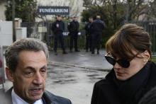 L'ancien président Nicolas Sarkozy (G) et Carla Bruni-Sarkozy parlent aux journalistes devant le fun