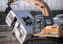 Un engin de chantier procède à l'enlèvement d'une caravane de la jungle de Calais, le 31 octobre 201