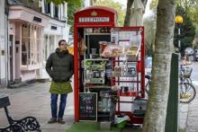 Umar Khalid debout devant le coffee shop qu'il tient depuis une ancienne cabine téléphonique à Londr